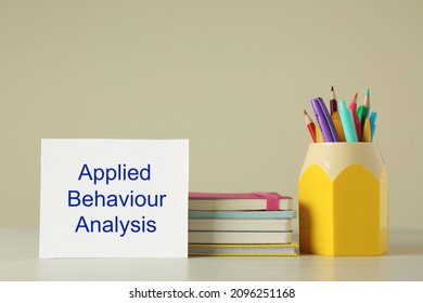 Set of stationery and card with text Applied Behavior Analysis on wooden table against beige background - Shutterstock ID 2096251168