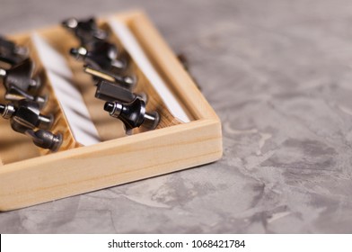 Set Of Steel Router Bit For Milling Cutter In Rectangle Wooden Box With Metal Lock On Old Broken Worn Gray Concrete Floor With Copy Space