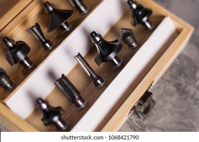 Set Of Steel Router Bit For Milling Cutter In Rectangle Wooden Box With Metal Lock On Old Broken Worn Gray Concrete Floor