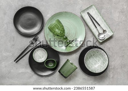 Set of stylish clean dinnerware on grey background
