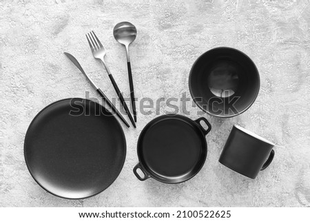 Set of stylish dinnerware on light grunge background