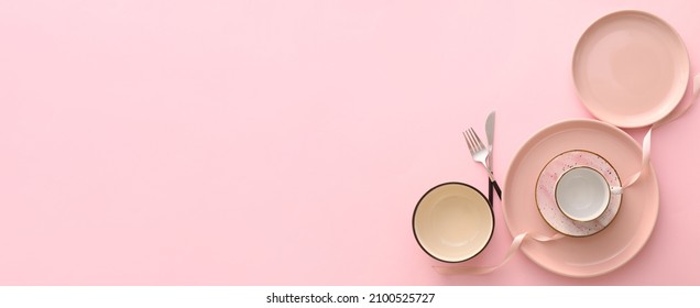 Set of stylish dinnerware on pink background with space for text