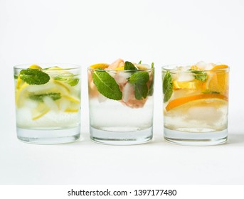 Set summer cold drinks with different citrus and herds in glasses on a white background. Cocktail with grapefruit, orange, lemon  and ice isolated