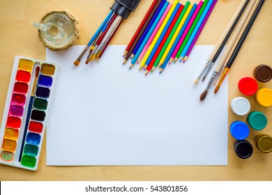 Set Of Supplies For Drawing: Watercolor Brushes, Color Palette, Gouache, Color Paper, Decanter With Water On Wooden Background. Art Painting Concept. Copyspace.