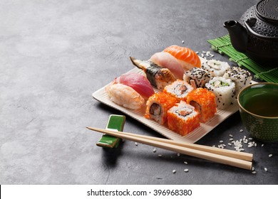 Set of sushi, maki and green tea on stone table. View with copy space - Powered by Shutterstock