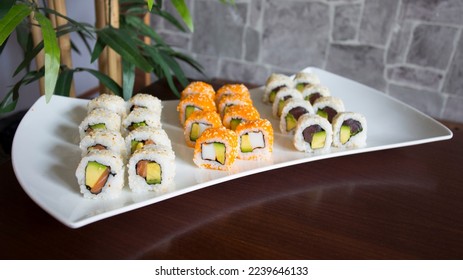 Set of sushi with variety of makis, nigiris and sashimi with fine fish like salmon and tuna.
