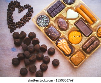 Set of sweets, cookies, coffee, chocolate truffles in a wooden box. on the table, coffee beans in the shape of a heart. a romantic gift for Valentine's day. - Powered by Shutterstock