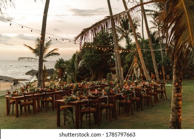 Set tables for a wedding dinner in a tropical garden. Concept of tropical beach wedding. Romantic sunset light