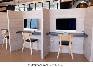 A set of tables, wooden chairs and a computer on the table.
