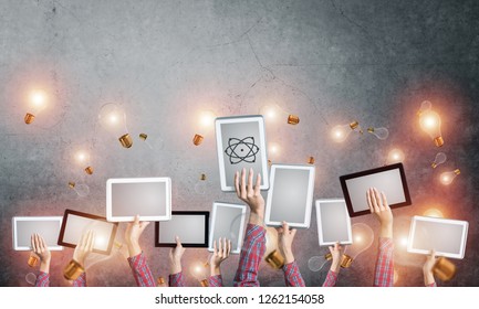 Set of tablets in female hands and glass bulbs fly around