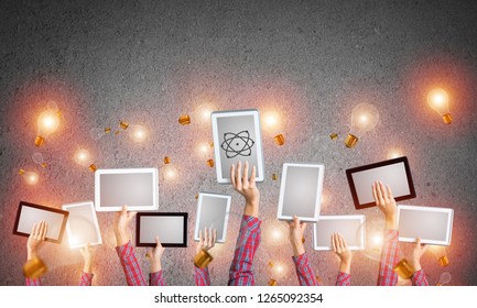 Set of tablets in female hands and glass bulbs fly around