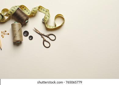 Set of tailoring tools and accessories on table, top view