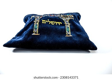  Un juego de tefillin y una bolsa iluminada con versos de Torah escritos sobre ellos.  Una bolsa que dice 