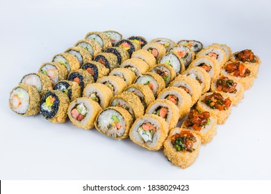 Set Of Tempura Sushi Roll Pieces With Seafood And Raw Fish. Variety Of Eastern Food Slices. Different Japanese Snacks Isolated On Background. Tasty Asian Food Fried In Breading, Served On Background