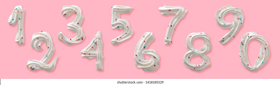 Set of ten Arabic numerals, edible figures made of white royal icing or meringue with colored sugar sprinkles. Top view isolated on pastel pink background. Confectionery decorative design.