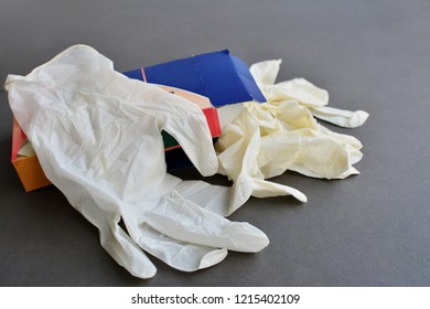 Set Of Thin Disposable Latex Rubber Gloves Taken Out Of A Box Over Gray Background