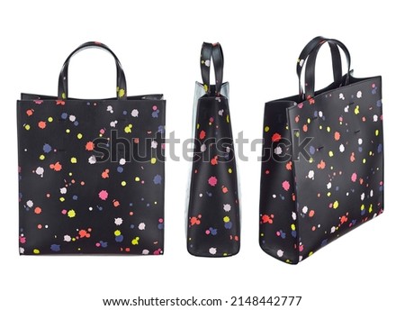 Set of three angles of a fashionable women's shopper-bag made of excellent quality black leather with a print in the form of randomly arranged bright colored blots, with handles isolated on a white.