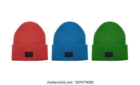Set of three colorful knitted beanie hats with black unbranded mockup label isolated on white background.