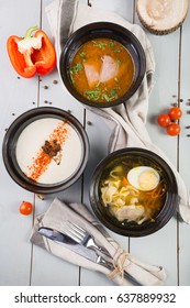Set of three different soups served on wooden table board