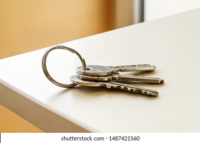 Set of three house keys on the ring on table in a room. Bunch of apartment keys. To forget keys at home consept. Close-up.