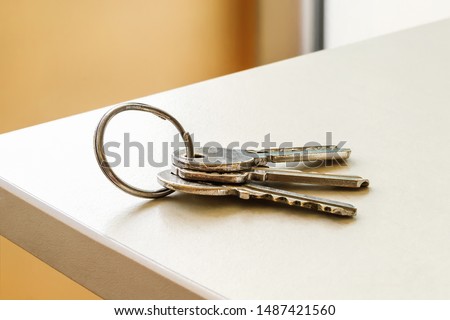 Set of three house keys on the ring on table in a room. Bunch of apartment keys. To forget keys at home consept. Close-up.