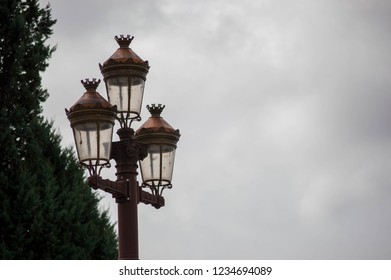 Set of three lampposts on a cloudy day
