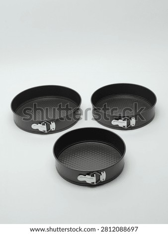Set of three round non-stick springform cake pans of different sizes, isolated on a white background.