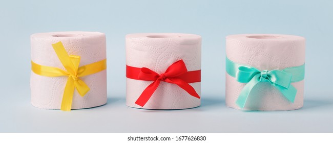 Set Of Toilet Paper Wrapped In A Gift Bow. The Concept Of A Valuable Actual Gift, A Meme On The Deficit In Supermarkets, Coronavirus Covid-19, Panic, Excitement And Shortage Of Goods, Banner