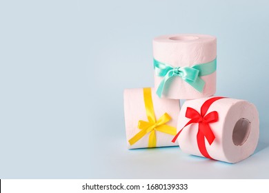 Set Of Toilet Paper Wrapped In A Gift Bow. The Concept Of A Valuable Actual Gift, A Meme On The Deficit In Supermarkets, Coronavirus Covid-19, Panic, Excitement And Shortage, Banner