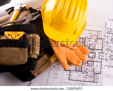set of tools and constuction plans with yellow helmet