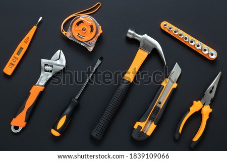 Set of tools on black background. Construction, DIY concept. Equipment,  workplace. Flat lay composition. Screwdriver, tape measure, wrench, knife, hammer and pliers. 