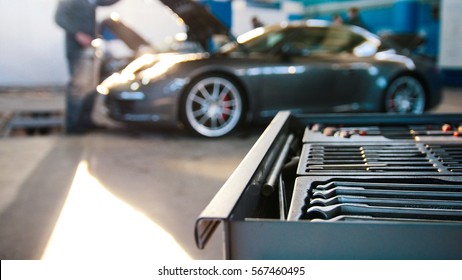 A Set Of Tools For Repair In Car Service In Front Of Luxury Sport Car, Wide Angle