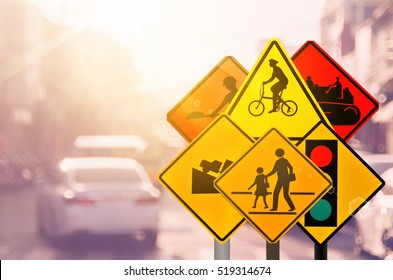 Set of traffic warning sign on blur traffic road with colorful bokeh light abstract background. Copy space of transportation and travel concept. Retro tone filter color style.