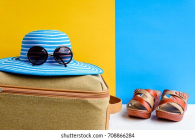 set travel and vacation with Blue hat sunglasses and bag orange shoe on wood table and colorful background