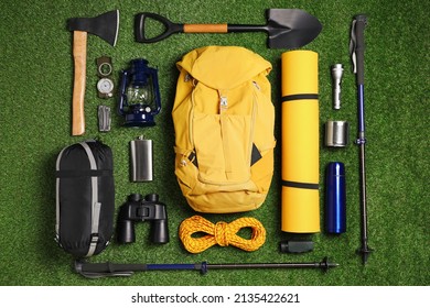 Set of traveler's equipment on green grass, flat lay - Powered by Shutterstock