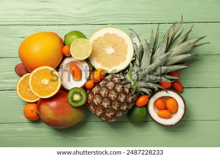 Set of tropical fruit on green wooden background, top view