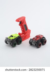 Set of two mini remote control monster trucks with transmitter controller on white background