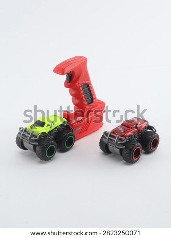 Set of two mini remote control monster trucks with transmitter controller on white background