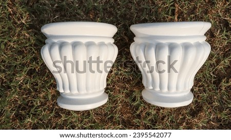 Set of Two plastic matki shaped fancy designer pot. Empty planter small size with curvy shape. Plastic pot container on green grass in house garden