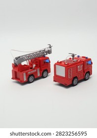 Set of two red toy fire trucks with extensible ladder on white background