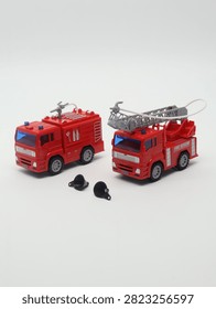 Set of two red toy fire trucks with extensible ladder on white background