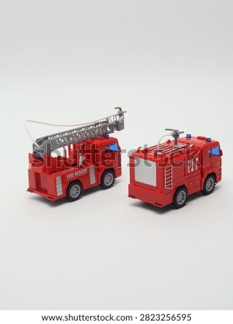 Set of two red toy fire trucks with extensible ladder on white background