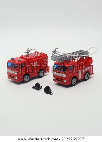 Set of two red toy fire trucks with extensible ladder on white background