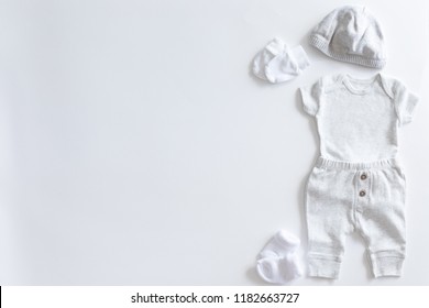 Set Of Unisex Clothing And Accessories For A Baby In Neutral Colors, Top View And Flat Lay On White Background