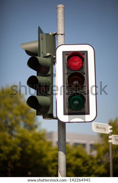 Set of urban robots\
mounted on a pole with the red traffic light illuminated bringing\
cars to a halt