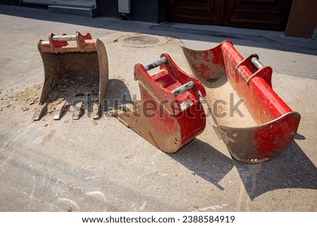 Set of used several different types of excavator's buckets, various types, sorted by size for precise digging in urban area.
