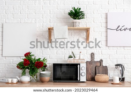 Set of utensils with microwave oven on kitchen counter