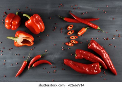 
A Set Of A Variety Of Red Pepper. On A Dark Background, Peppers Are Cayenne, Sweet And Ramiro Sort. In The Frame, Half A Sweet Pepper And The Chili Pepper Is Cut With Mugs. Close-up. View From Above.