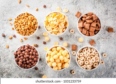 Set Of Various Breakfast Cereal Corn Flakes, Puffs, Pops, Grey Stone Table Copy Space Top View