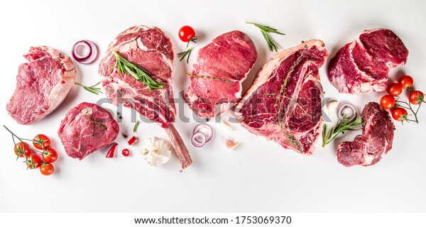 Set of\
various classic, alternative raw meat, veal beef steaks - chateau\
mignon, t-bone, tomahawk, striploin, tenderloin, new york steak.\
Flat lay top view on white table\
background
